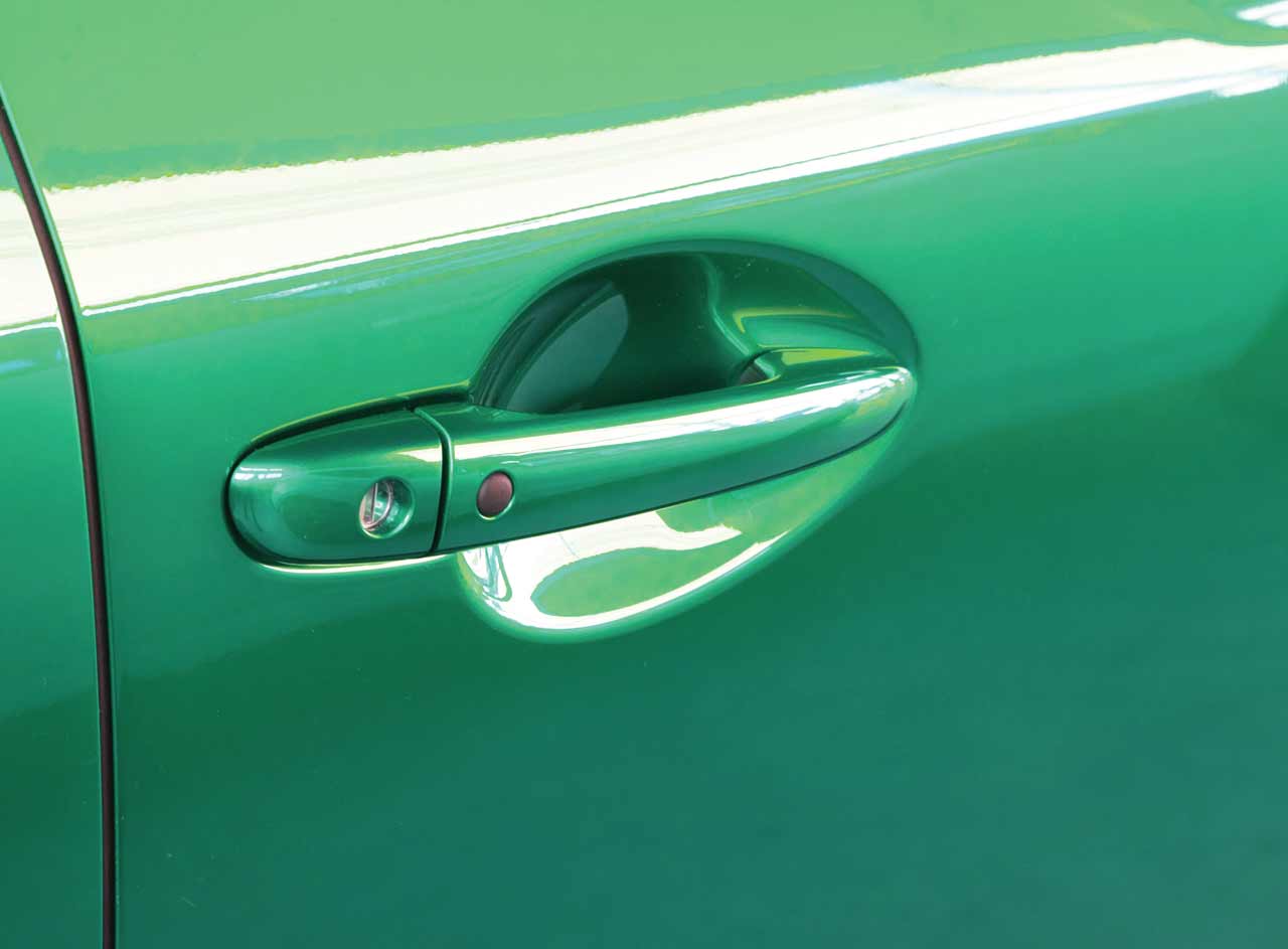 Platinum Gloss PPF Series on the door handle of a green car<br />