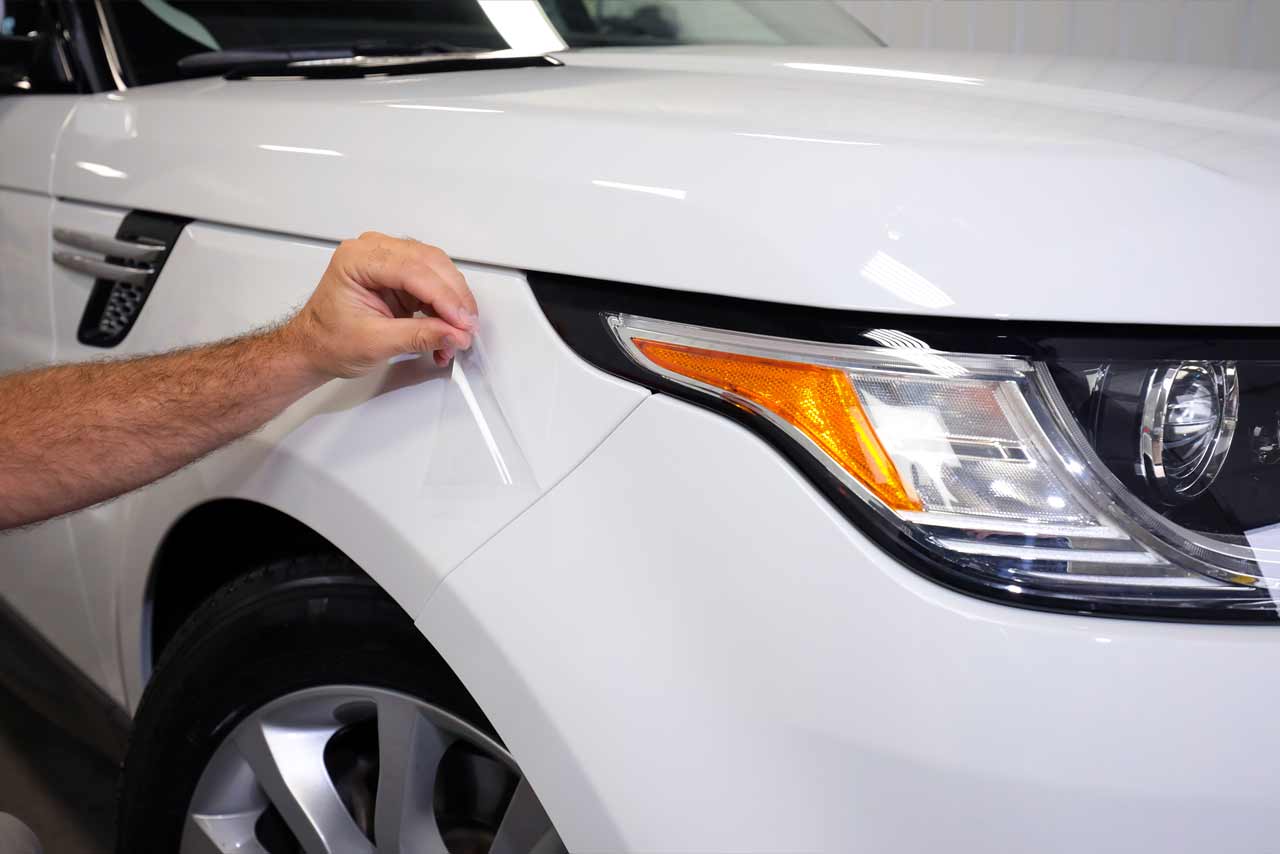 Platinum Gloss PPF being installed by a technician on a white SUV